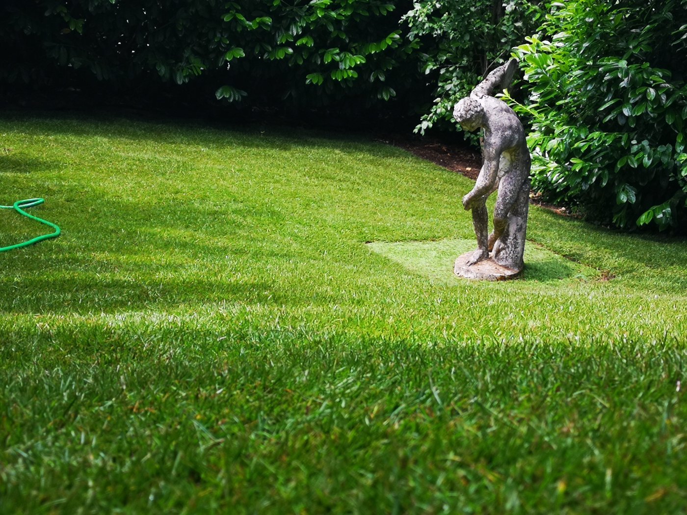 Gepflegte Rasenfläche mit Steinfigur
